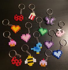 six pixel keychains with different designs and colors are shown on a black surface