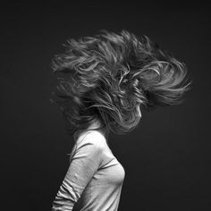 a woman with her hair blowing in the wind, black and white photograph by person