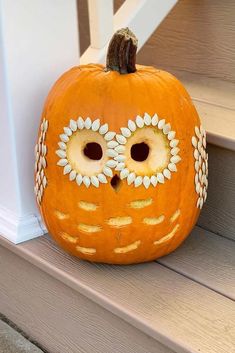 an orange owl pumpkin sitting on the steps