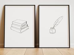 two framed books and a feather quill are on the floor next to each other