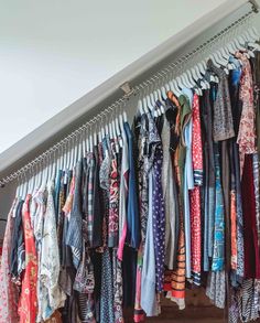 an assortment of clothes hanging on a rail