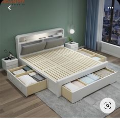 a bed with drawers underneath it in a room next to a window and a rug on the floor