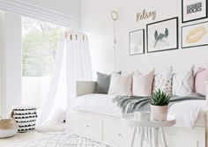 a bedroom with white furniture and pictures on the wall, including a bed in front of a window