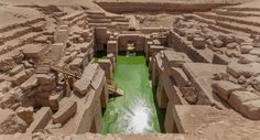 an ancient water source in the desert with green water flowing from it's sides