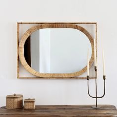 a wooden table with a mirror and candles on it next to a wall mounted candle holder