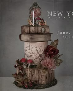 a cake that is sitting on top of a tree stump with flowers and mushrooms around it