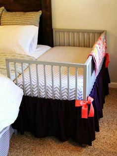 a white crib with two pillows on top of it