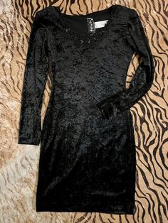 Crushed black velvet party dress Stretchy fabric! Beaded detailing around collar Fits XS/Small measurements unstretched Bust 34” shoulders 16.5” slight padding sleeve 23” length 35” Glamorous Velvet Bodycon Dress For Night Out, Velvet Bodycon Dress For Night Out, Glamorous Velvet Mini Dress For Party Season, Velvet Fitted Mini Dress For Party Season, Fitted Velvet Dress For Night Out Party Season, Fitted Velvet Dress For Party Season Night Out, Velvet Dress For Night Out And Party Season, Velvet Dress For Night Out Party Season, Velvet Dresses For Night Out And Party Season