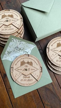 four wooden coasters are sitting on a table with envelopes and papers next to them