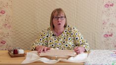 a woman sitting at a table with some napkins on her lap and making a funny face