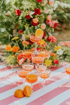 a table topped with lots of glasses filled with oranges