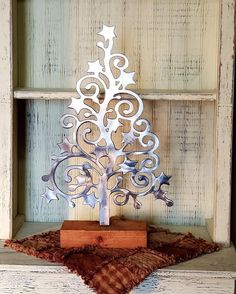 a metal christmas tree sitting on top of a wooden shelf