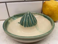 a ceramic bowl with a lemon on the side