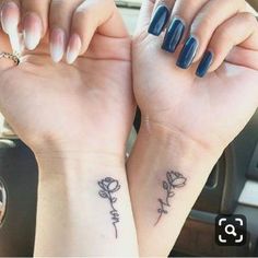 two women with matching tattoos on their arms holding each other's hands in the car