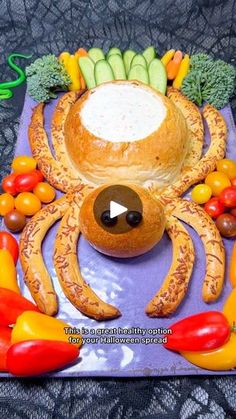 a cake made to look like a spider with fruits and vegetables around it