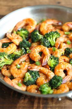 shrimp and broccoli in a skillet on a wooden table