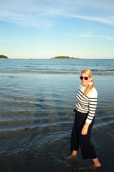 a woman standing in the water at the beach