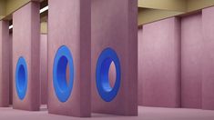 three blue circles are in the middle of an empty room with pink walls and flooring