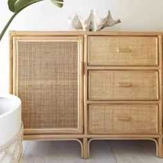 an old bamboo dresser with two birds on top