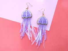 These purple beaded jellyfish earrings would make a perfect and unique gift for family, friend, or yourself. ★DIMENSIONS: 12*3.5 cm (4.72*1.37 Inches) ★READY TO SHIP Made with love and care about you!♥ ★The colors can slightly differ from the photo because of photography lighting and monitor settings. ★ESTIMATED SHIPPING TIMES: North America: 2-4 weeks Europe: 1-3 weeks Australia, New Zealand and Oceania: 3-5 weeks Asia Pacific: 2-4 weeks Latin America and the Caribbean: 3-5 weeks North Africa and the Middle East: 3-5 weeks Sub-Saharan Africa: 3-5 weeks ★PLEASE NOTE: I accept payments through Paypal * you no need to have an account* by credit or debit card. 1. Click Check out with PayPal and you'll be redirected to PayPal. Instead of choosing to pay with your PayPal account, select Pay wit Jellyfish Beads, Beaded Jellyfish, Jellyfish Earrings, Embroidered Earrings, Purple Beaded, Sea Animal, Photography Lighting, Animal Earrings, Family Friend