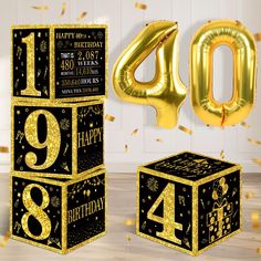 a black and gold birthday party with balloons, streamers and numbers on the floor