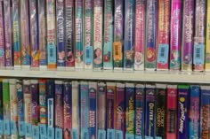 the shelves are filled with various disney princess books and dvds, all in different colors