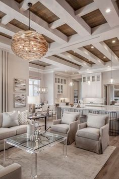 a living room filled with lots of furniture and a chandelier hanging from the ceiling