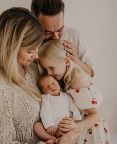 a man and woman holding a baby in their arms