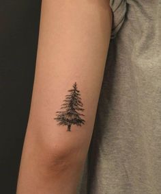 a small pine tree tattoo on the arm