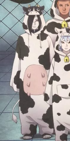 two people in costumes standing next to each other with cows on their heads and cats on their backs