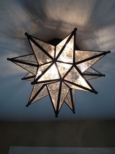 a star shaped light fixture hanging from the ceiling