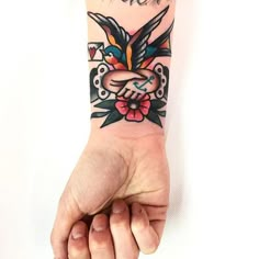 a person holding their hand up with a bird tattoo on it's left arm