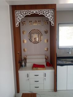 a kitchen area with white cabinets and gold decorations on the wall, along with a wooden table