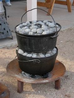 three buckets stacked on top of each other with rocks in them sitting on a wooden platform