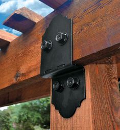 two black speakers are attached to the side of a wooden structure with blue sky and clouds in the background