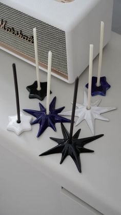 five candles are placed in the shape of stars on top of a white countertop