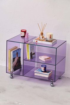 a purple shelf with books and magazines on it