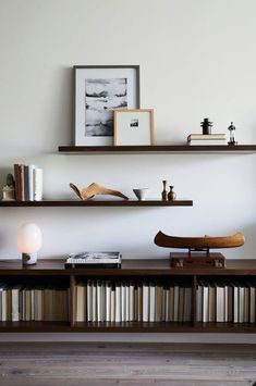 two shelves with books and other items on them in a living room or dining room