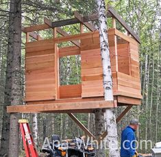 a man working on a tree house in the woods