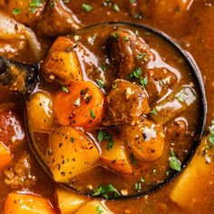 a spoon full of stew with potatoes and carrots