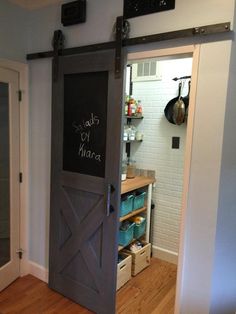 an open barn door with chalkboard written on it in the middle of a kitchen