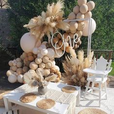 the table is set up with white chairs and tables covered in different types of decorations