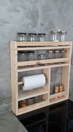 a shelf filled with jars and containers on top of a stove burner next to a wall