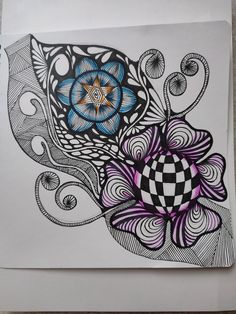 an artistic drawing on white paper with purple and blue flowers in the center, surrounded by black and white swirls