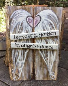 two angel wings painted on wood with words