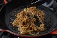 onions being cooked in a skillet on the stove