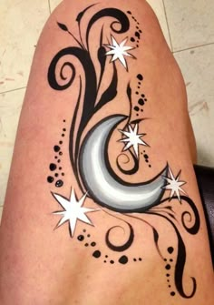 a woman's leg with stars and crescent tattoo on it