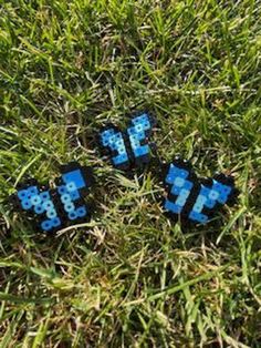 three blue and black lego blocks sitting in the grass