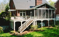 a large house with a porch and stairs leading up to it