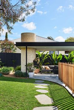 an outdoor living area with green grass and wooden fenced in areas around the house